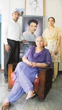 Arun Batalvi, wife of Shiv, with her son and daughter-in-law pose by the poets portrait in their Patiala home. 