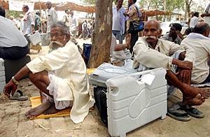 Polling officials wait with their electronic voting machines after being assigned duties in Rae Bareli district on Sunday. Polling in the Rae Bareli byelection is scheduled for Monday.