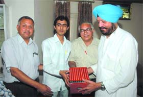 Akashdeep Paul, a B.Com-II topper from Lyallpur Khalsa College, being awarded a set of encyclopaedia by Balbir Singh, President of the College Governing Council, and Satish Kapoor, college Principal