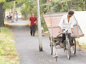 A rickshaw puller tries to juggle his way through supporting wires of an electricity pole in the middle of the road in Sector 28, Chandigarh
