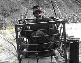 An elderly of Dullanja village uses the trolley/ropeway to cross over to the other side of the Jhelum. Dullanja is connected to the world only through this rickety ropeway.
