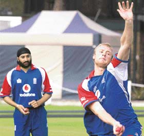 Englands Andrew Flintoff bowls as Monty Panesar looks on during a training session at the Lords cricket ground in London