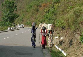 Women of the Mandi area carry water containers on their heads in view of the water crisis being faced in the place