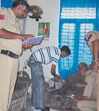 Police officers inspecting the spot where the woman was done to death in the Capital on Sunday.