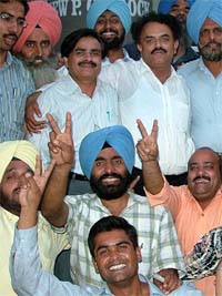 The newly-elected President of the Punjab and Chandigarh College Teachers Union H.S. Walia and General Secretary Jagwant Singh (both standing in the centre) celebrate their victory in Jalandhar
