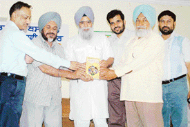 Mr Ajmer Singh Aulakh (second from left), president of the Kendriya Punjabi Lekhak Sabha, releases a book, Chugli de Rang, at Dera Bassi on Tuesday. 