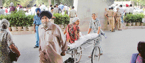 a patient is wheeled out of the PGI OPD following a strike by junior and senior doctors of the hospital in Chandigarh on Tuesday.