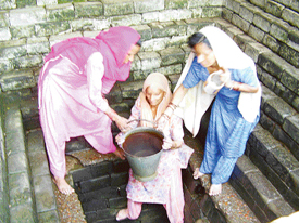Village women take water from the receded baoli at Kango. 