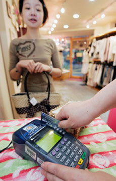 A shopkeeper swipes a credit card in Taipei on Wednesday.