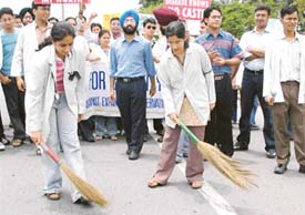 Students of the Government Medical College and Hospital take to the streets with brooms in protest against reservation in Chandigarh on Wednesday. 