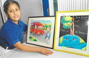 Simran Sidhu stands by the side of her artworks at her solo exhibition, put up at Ryan International School, Sector 49, Chandigarh.
