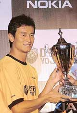Indian football star Baichung Bhutia holds a trophy during the launch of the Defend Your Turf Futsal Challenge street football series in New Delhi on Friday