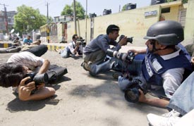 Journalists take shelter during an attack by militants on Chief Ministers rally in Srinagar on Sunday