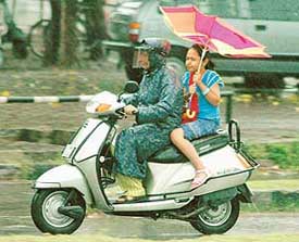 Heavy showers caught this scooterist and the pillion rider unawares in Chandigarh on Monday. 