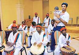 Indian captain Rahul Dravid, holding his child Samit, is welcomed by drummers upon arrival at The Marriott hotel in Frigate Bay, St Kitts, on Sunday. The third one-dayer between India and the West Indies will be held on Tuesday.