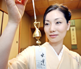 A model in kimono dress displays a gold windbell-shaped stork