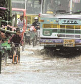 A child trying to negotiate past buses on a flooded road in the Azadpur area after heavy rain