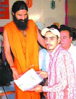 Swami Ramdev giving award to a student of DAV College in Jalandhar on Tuesday