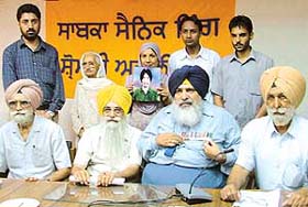The wife of the late Lance Dafedar Harmit Singh of 5 Armoured Regiment shows a photo of her husband to mediapersons in Ludhiana