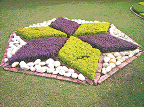 One can decorate outside-the-house garden by the use of ground-cover plants or stones and pebbles leaving at least three feet clearance on the berm from the road as passage for the pavement users.