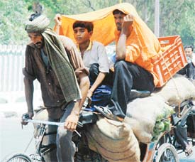 With mercury touching 43 degrees in Ludhiana, riders in a rickshaw take shelter under a cloth