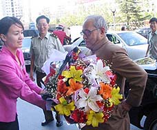 Defence Minister Pranab Mukherjee is presented a bouquet in Beijing on his arrival