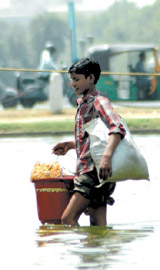 A street vendor walks through the Boat Club pond in the Capital on Tuesday. 