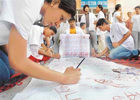Medicos put their signatures in blood on an anti-quota cloth banner in Ludhiana