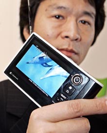 Toshiba's mobile entertainment products division senior manager Hitoshi Inaba displays a new multimedia player "gigabeat V30T"