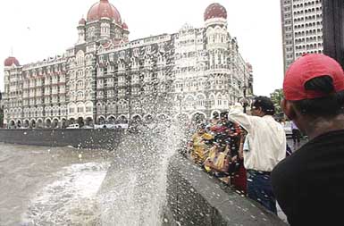 Local tourists are caught unawares by a sea water wave at the Gateway of India in Mumbai on Thursday.  The monsoon arrived several days earlier than expected and city officials had not yet completed anti-flooding measures, including finishing a project to dredge a river that runs through the city. 