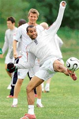 Englands Ashley Cole stretches for the ball as captain David Beckham looks on as the team trains at Carrington near Manchester on Friday