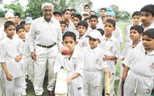 D.P. Azad with budding cricketers of his academy at St Stephens School, Sector 45, Chandigarh, on Saturday.