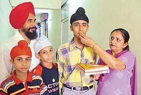 An elated Manveer Singh, who has topped JET, being given sweets by his parents in Ludhiana