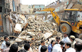 Fire and police personnel clearing away the debris of a collapsed building. Two persons were killed and many injured in the mishap at Mangolpuri in the Capital on Sunday