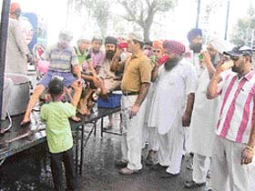 Passersby drink sweetened water at a chabeel organised by the sangat of Nanaksar Ashram Thath in Mandi Ahmedgarh