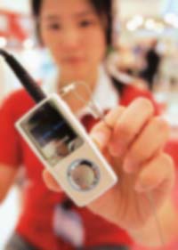 A woman displays a flash MP3 player during the Computex computer fair at Taipei