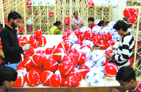 Football Mania: Children check brand new footballs at a factory in Jalandhar in this file photo. 
