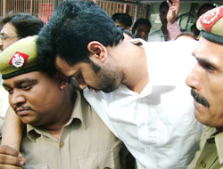 Rahul Mahajan, who was remanded in 14-day judicial custody, being taken by policemen as he faints at the Patiala House Court in New Delhi on Thursday. 