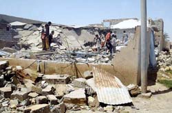Iraqi children search among the rubble of one of four houses believed to be destroyed by US forces in the town of Hibhib