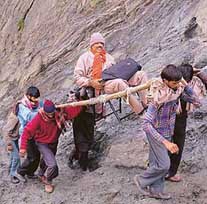 Potters carry a pilgrim on a palanquin to the holy cave on Saturday.