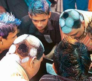 A fan gives his head the shape of a football while the other goes for a hairdo in line with the England captain David Beckham in Mumbai on Saturday.
