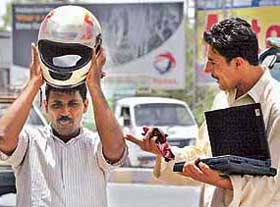 A Pakistani street vendor holds a laptop as he bargains with a commuter in Rawalpindi
