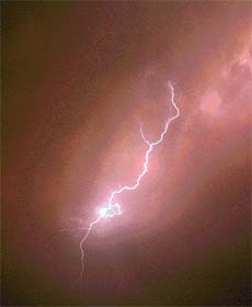 Lightening crackles in the sky as heavy rain and thunder hit the city in the evening