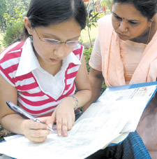 A student being helped by her mother to fill up an admission form at Delhi University in the Capital on Monday