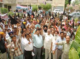 Leaders and residents protest outside the Ludhiana Improvement Trust office in Ludhiana on Monday