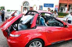 Viewers take a look at the new model of Mercedes Benz passenger car at a road show in Bhopal