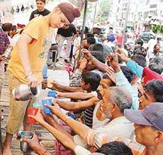 Sweetened water being served to people in connection with the martyrdom day of Guru Arjan Dev in Ludhiana on Wednesday. 