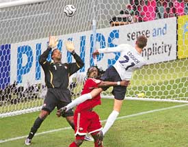 Englands Peter Crouch scores his teams first goal as Trinidad and Tobagos Brent Sancho collides with him while goalkeeper Shaka Hislop looks on during their Group B match in Nuremberg