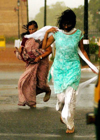 Women rush as they get caught in a stormy afternoon in New Delhi on Friday. 