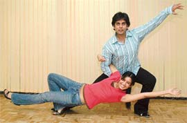 A beaming salsa couple strikes a dance pose. 